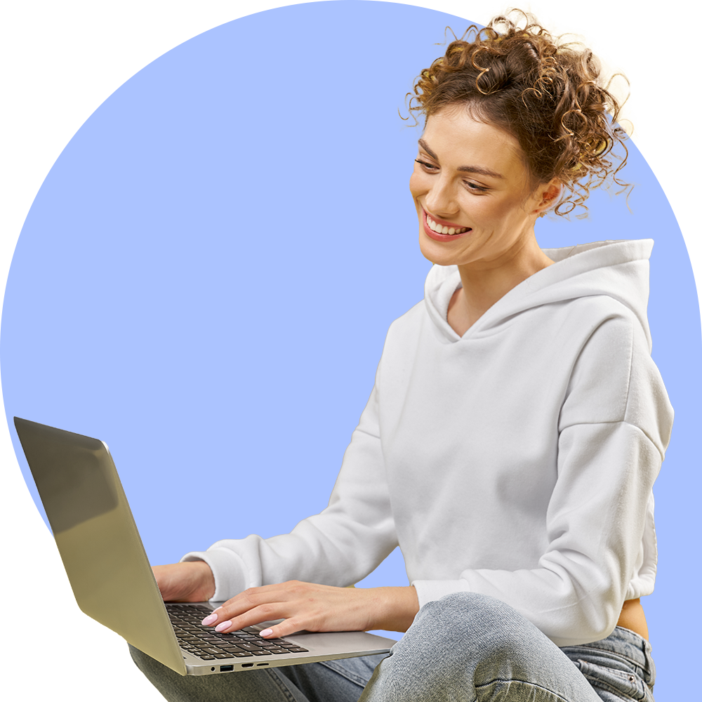 Mujer rizada usando una computadora sonriente